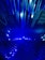 A dynamic and futuristic display featuring numerous elongated blue light beams arranged in a radiating pattern, creating a sense of movement and depth.