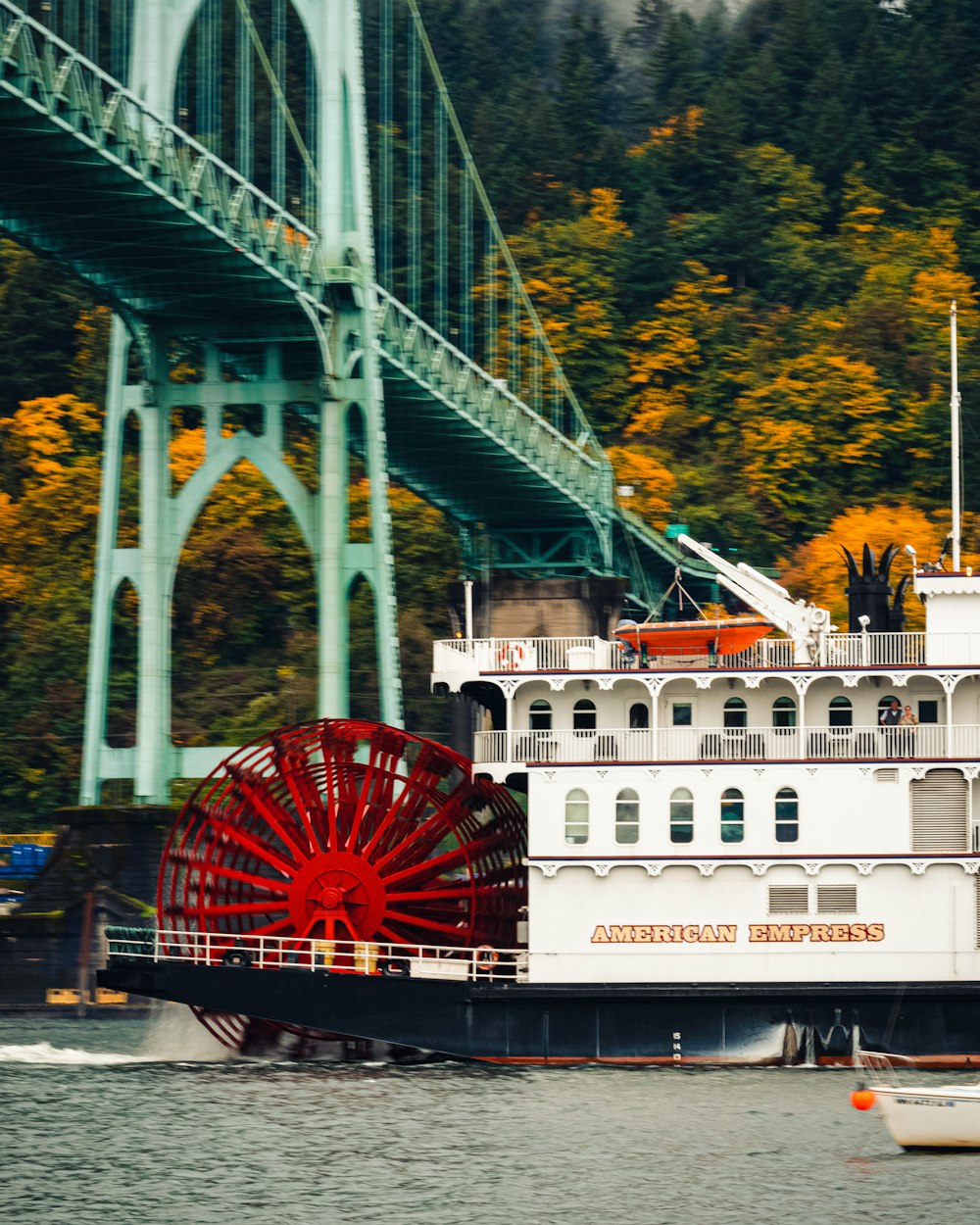 a large boat on the water near a bridge