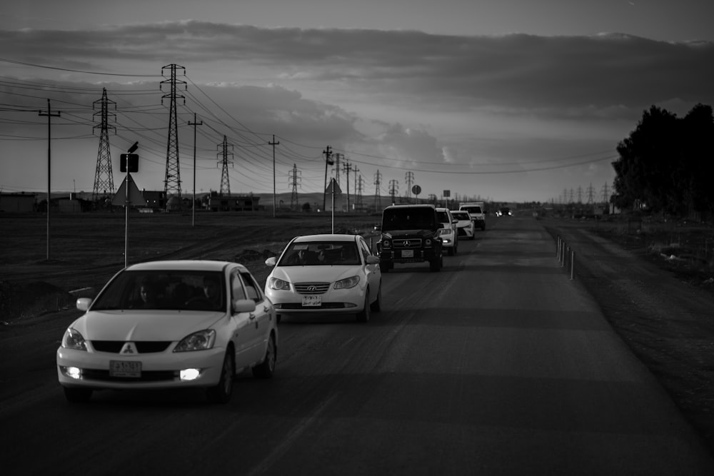 a black and white photo of cars on a road