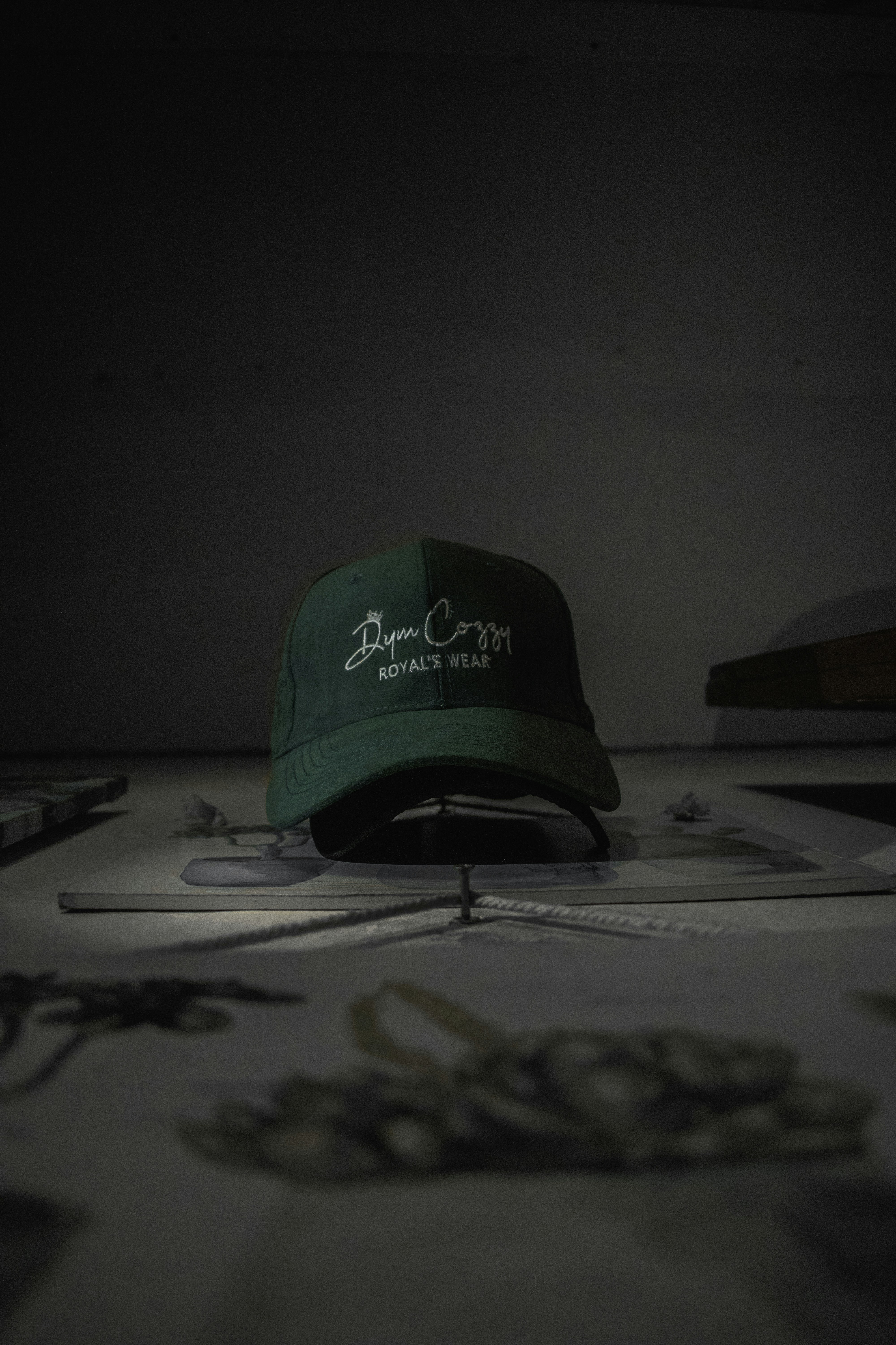 Stone canvas baseball cap on dark surface, front panel showing embroidery