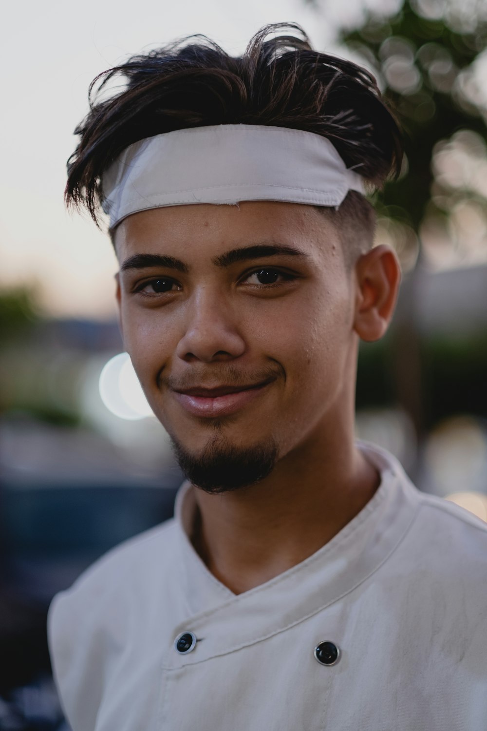 a man with a headband on smiling at the camera