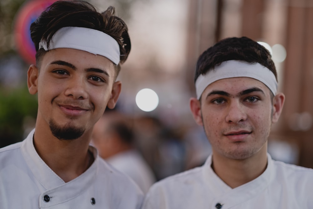 dois jovens em uniformes de chef de cozinha de pé um ao lado do outro