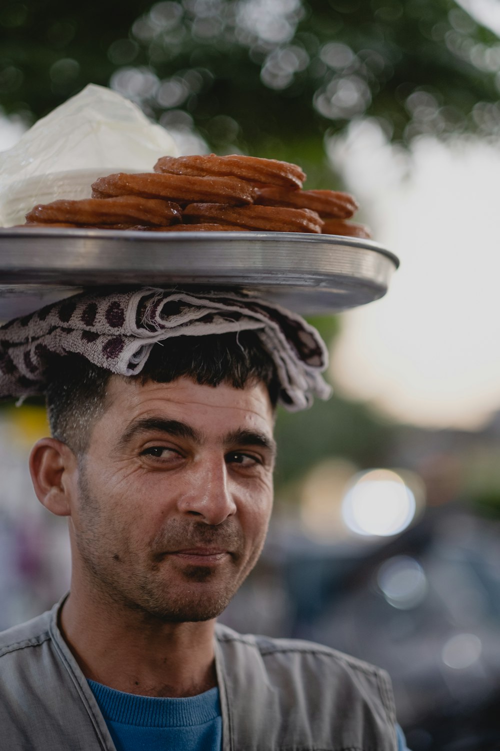 um homem com uma bandeja de donuts na cabeça