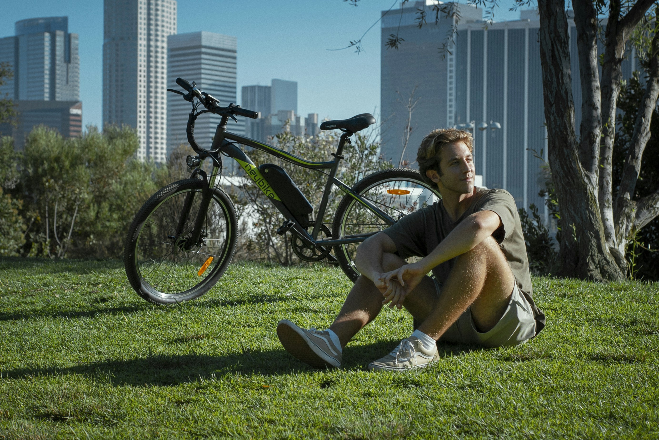 Un hombre sentado en la hierba junto a una bicicleta