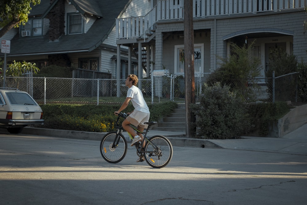 a woman riding a bike down a street