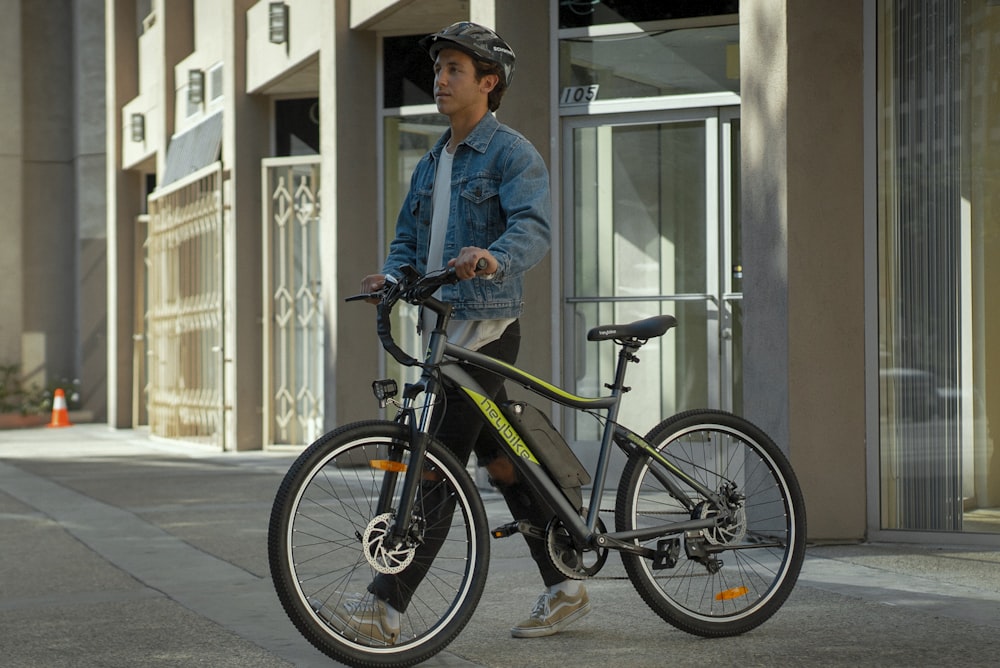 a man riding a bike down a street next to a tall building