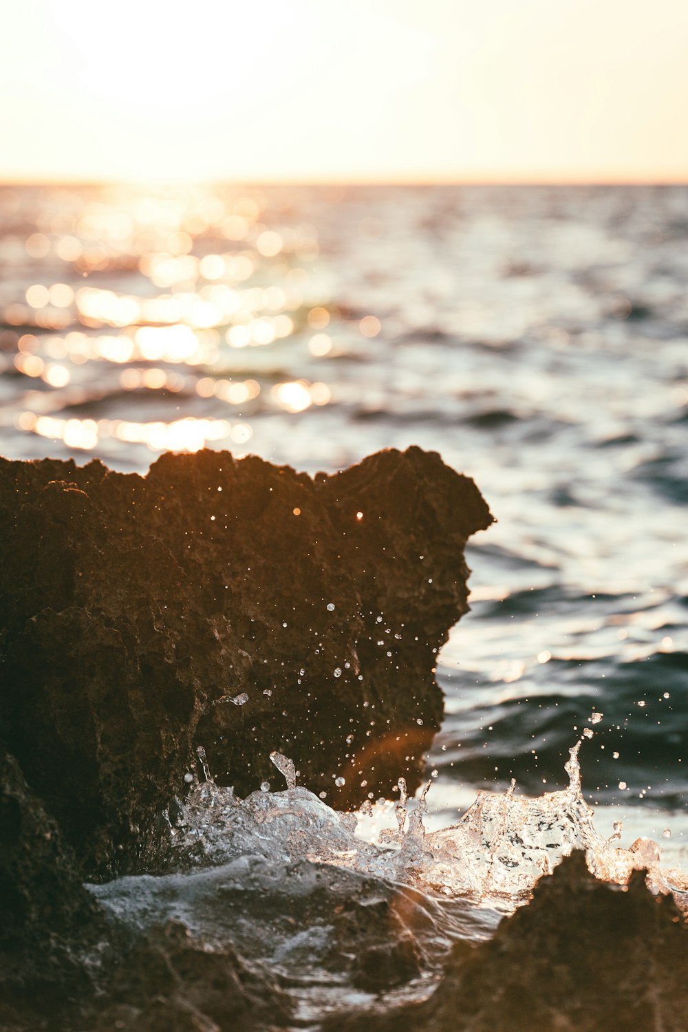 a rock sticking out of a body of water