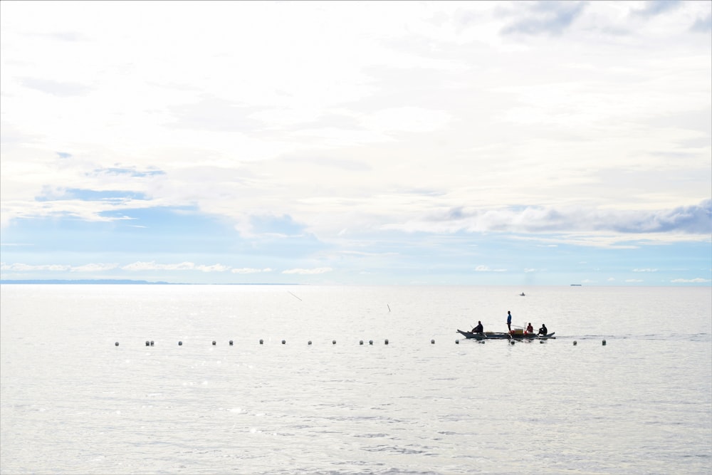 a group of people on a boat in the middle of the ocean