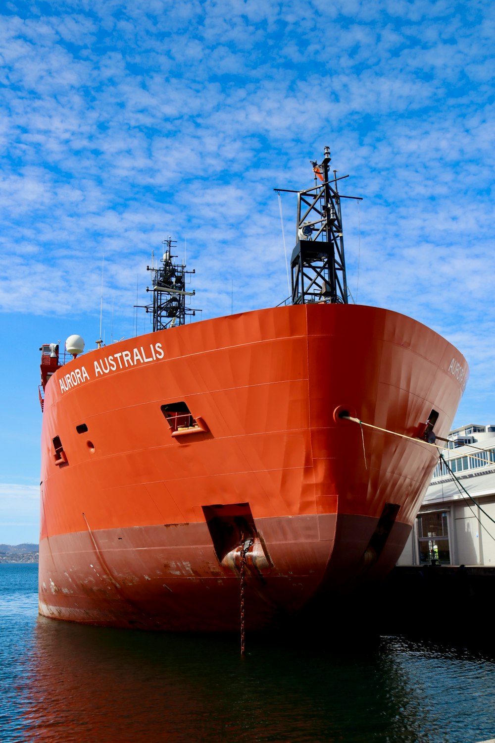 a large orange boat docked at a dock