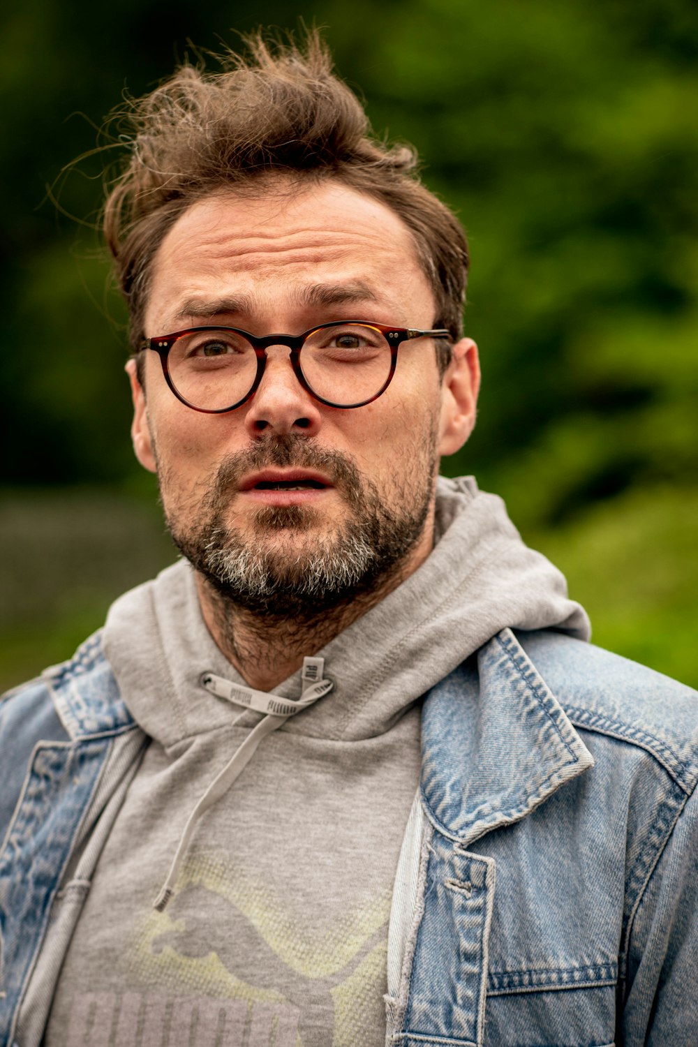 a man wearing glasses and a denim jacket