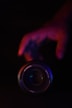 a hand holding a camera lens in the dark