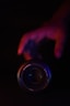 a hand holding a camera lens in the dark