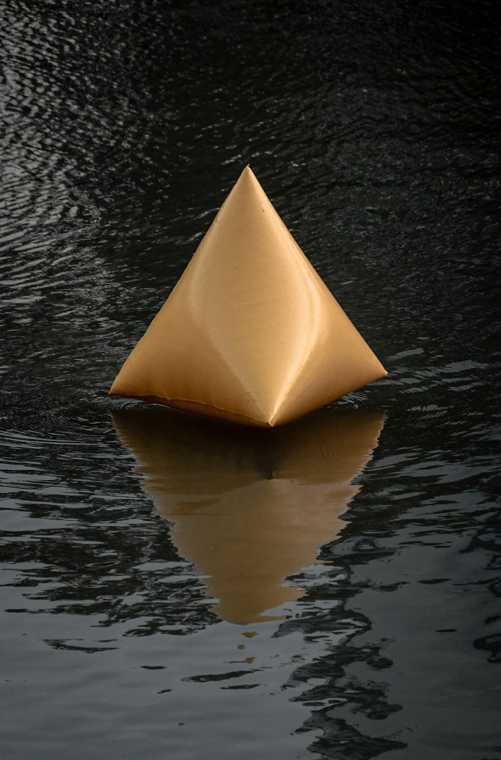 a golden object floating on top of a body of water
