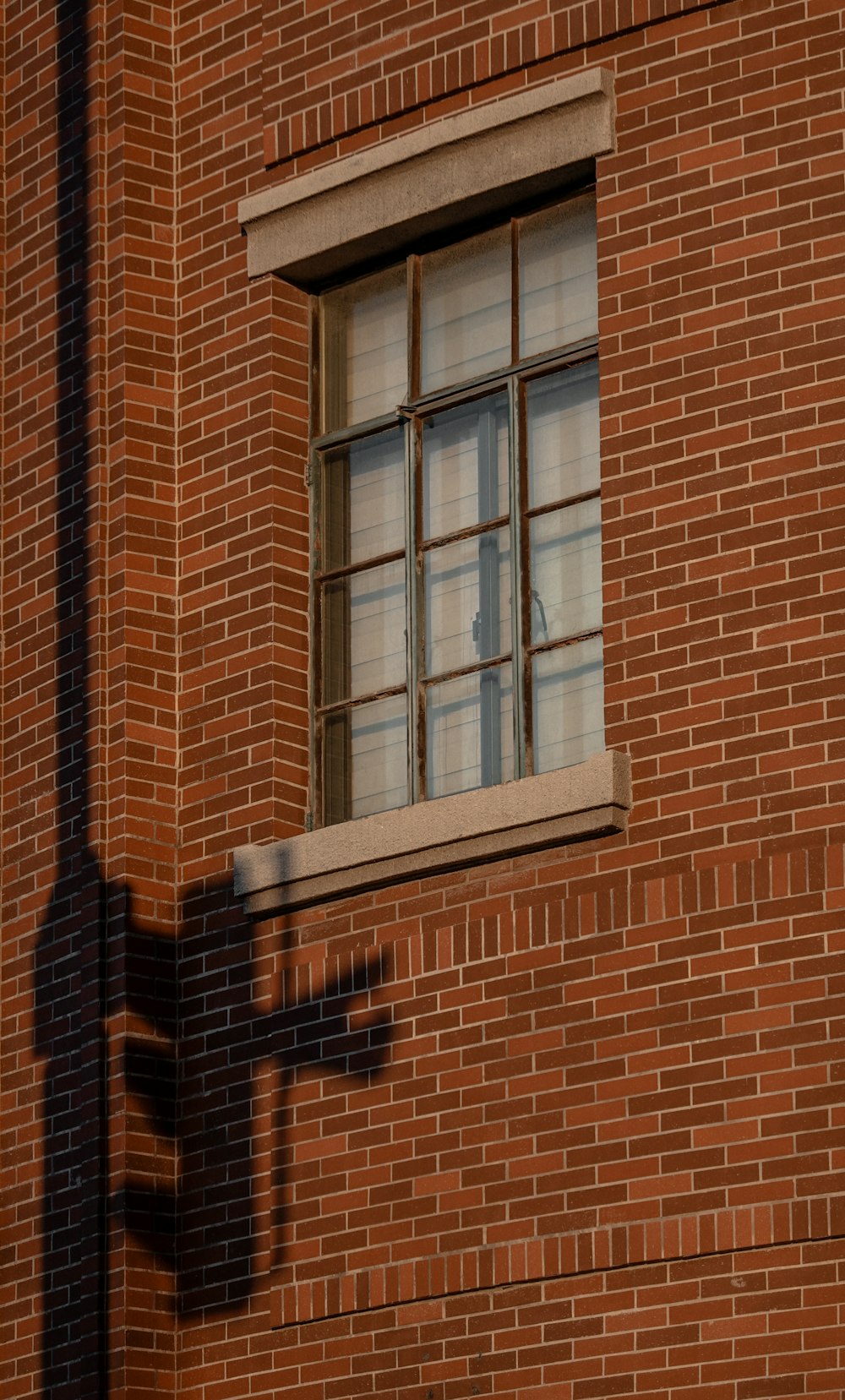 a shadow of a street sign on a brick building