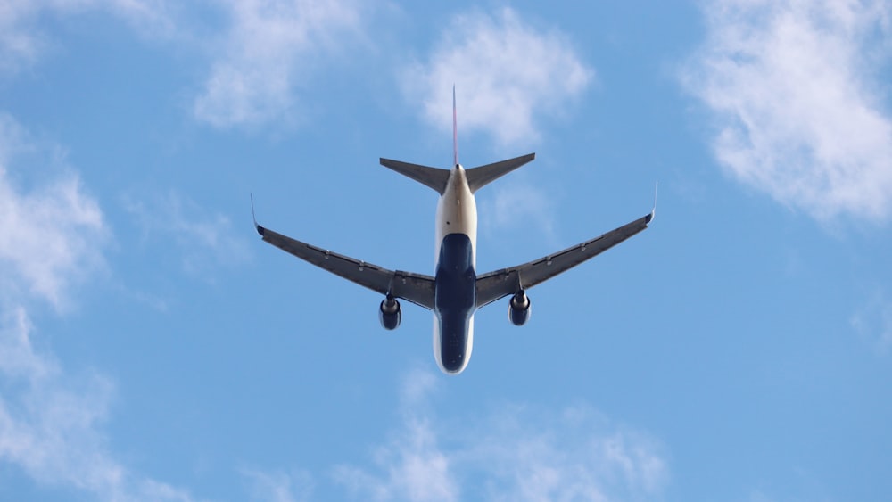 a large jetliner flying through a blue cloudy sky