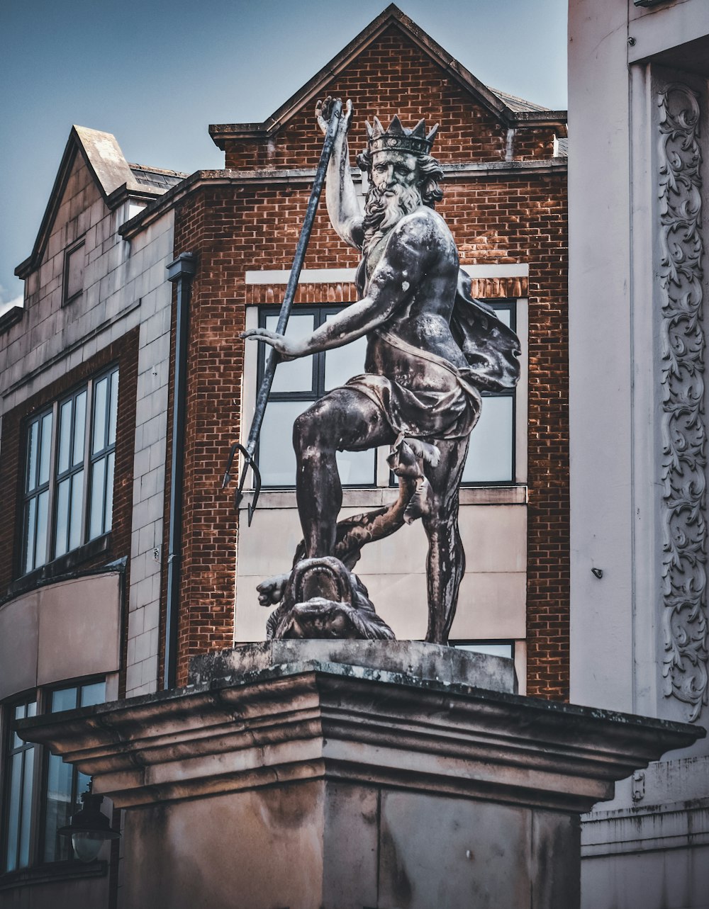 Una estatua de un hombre sosteniendo una espada en la parte superior de un edificio
