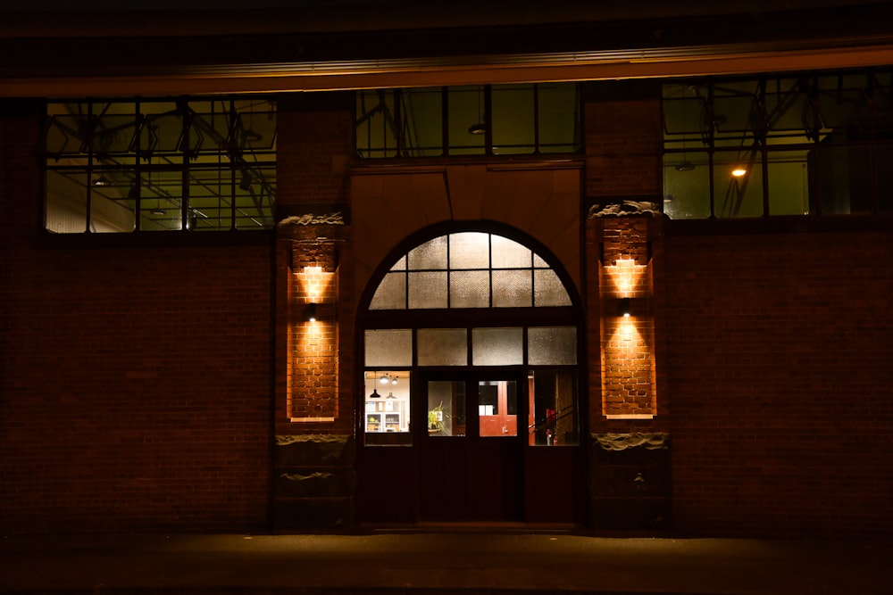 un bâtiment en brique avec une entrée éclairée la nuit