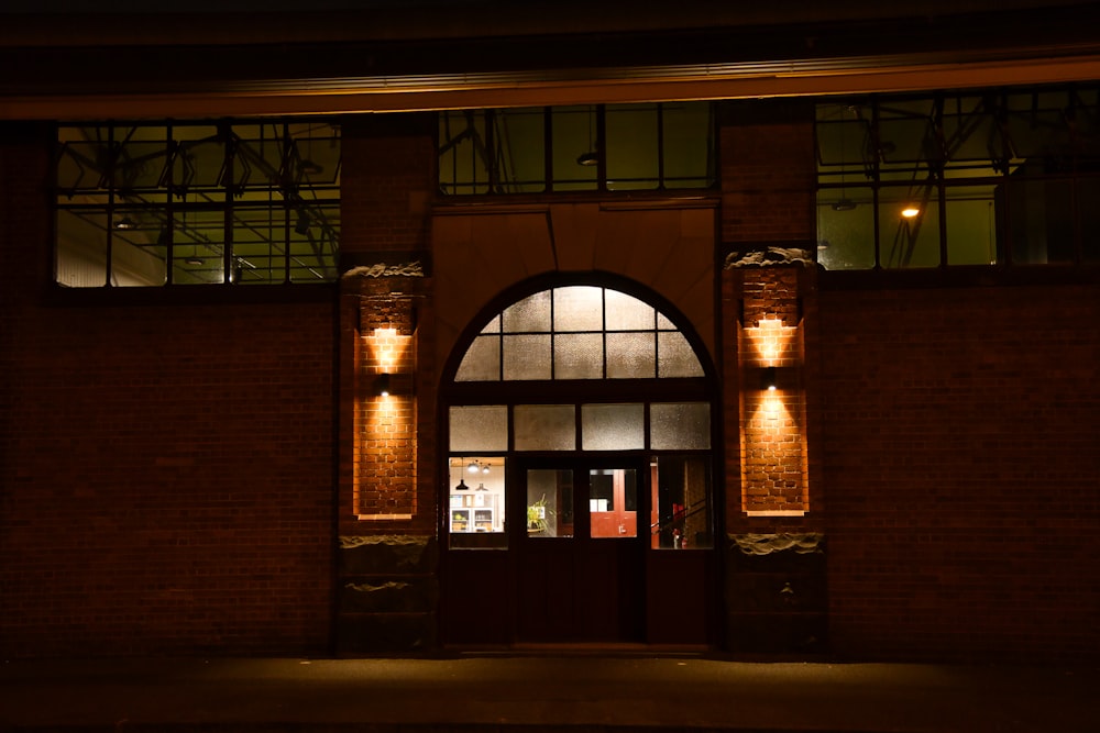 a brick building with a lit up entrance at night