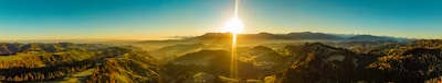 A panoramic view of a sunrise over a mountainous landscape.
