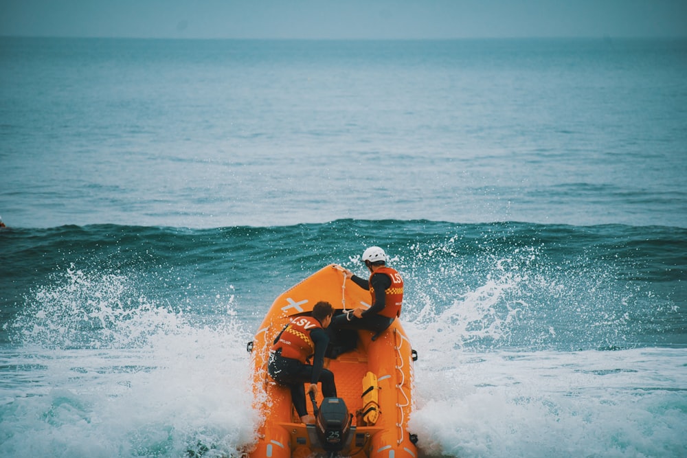 Dos personas en una balsa naranja en el océano