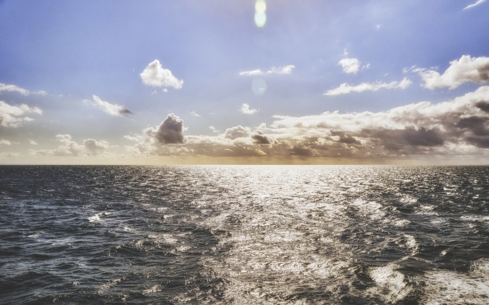 the sun is shining through the clouds over the ocean