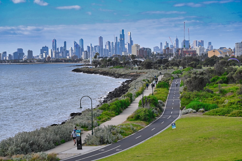 a man riding a bike down a road next to the ocean