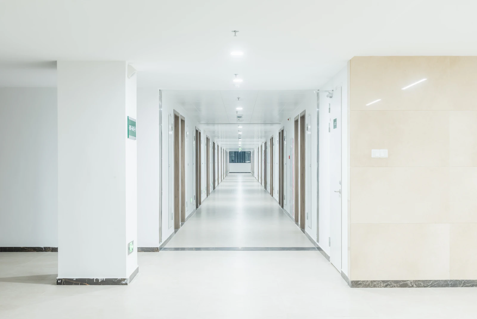 A long hallway with white walls and doors
