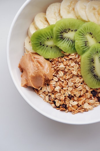a bowl filled with oats, kiwi, and peanut butter