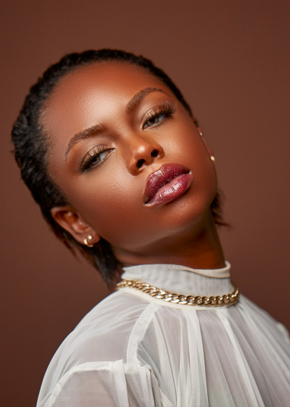 a woman wearing a white shirt and gold necklace