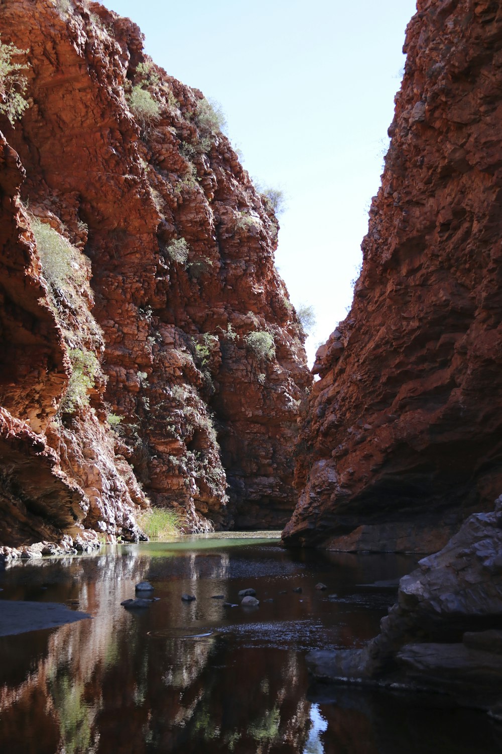 a body of water surrounded by red rocks