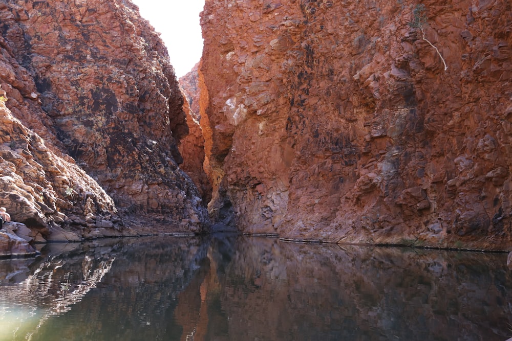 a person is sitting on a rock near a body of water