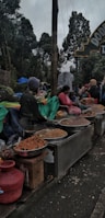 Wide shot of a bustling market with various seasonal goods on sale.