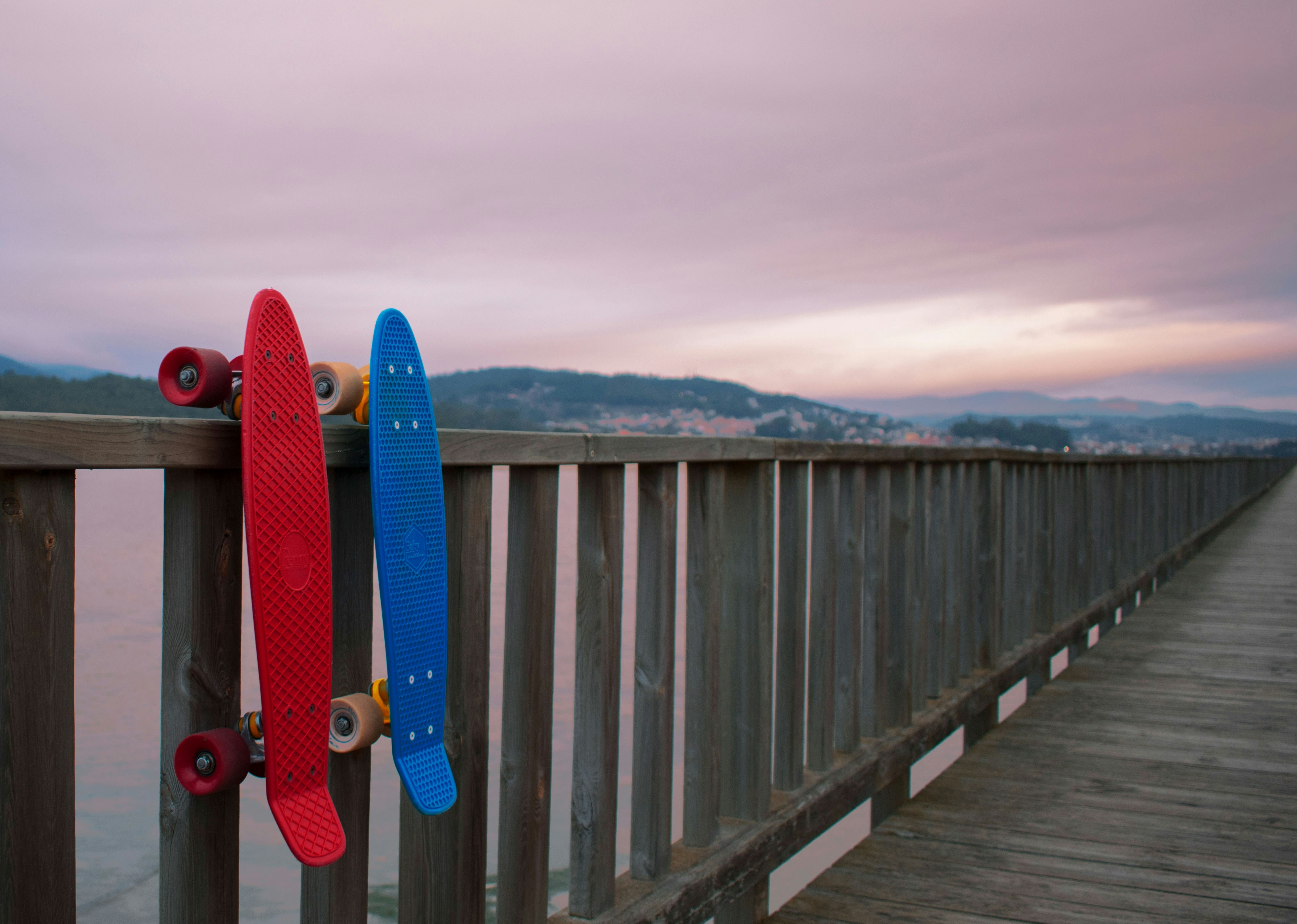 two skateboards are leaning against a rail