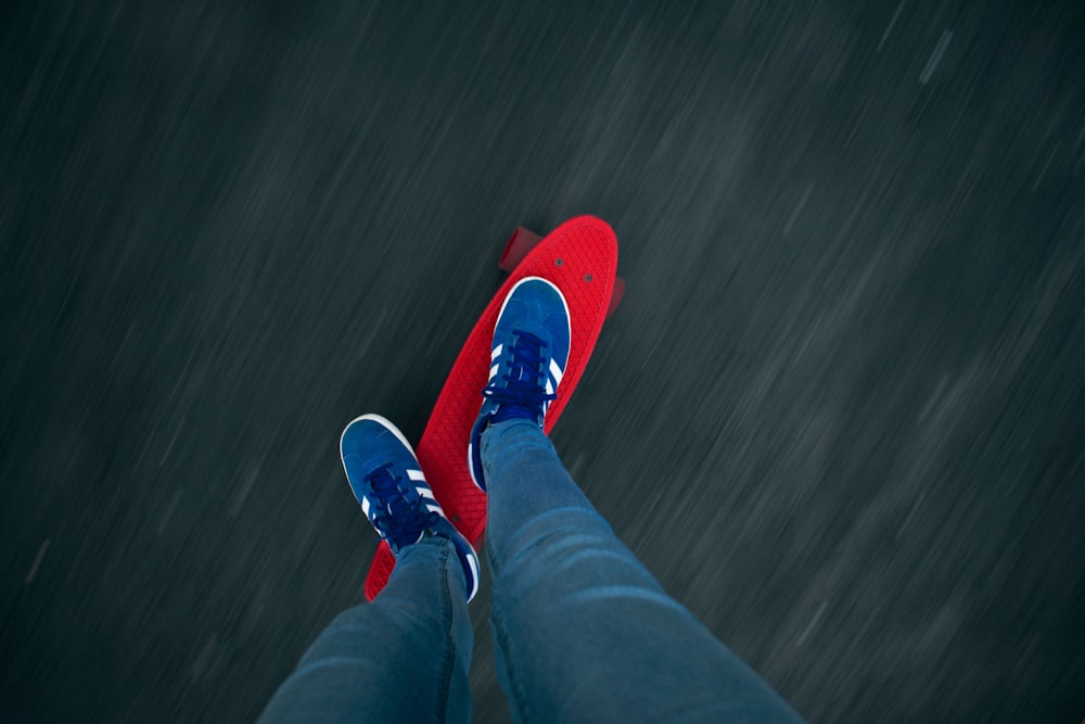 a person standing on a skateboard in the rain