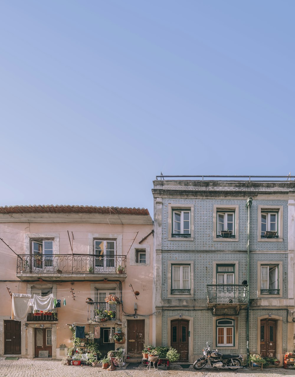 a row of multi - story buildings on a cobblestone street