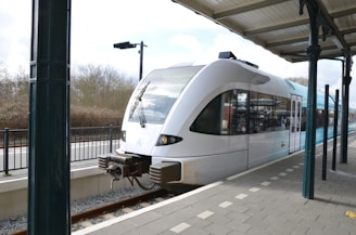 A sleek cab waiting outside a modern train station under a clear sky.