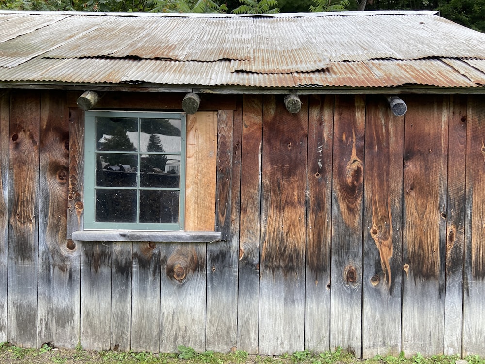 a wooden building with a window and a tin roof