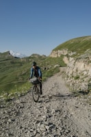 a man riding a bike down a dirt road