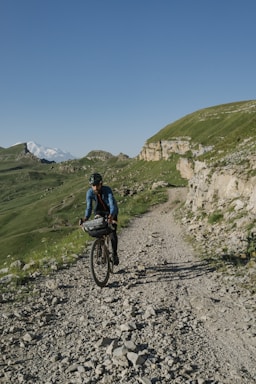 a man riding a bike down a dirt road
