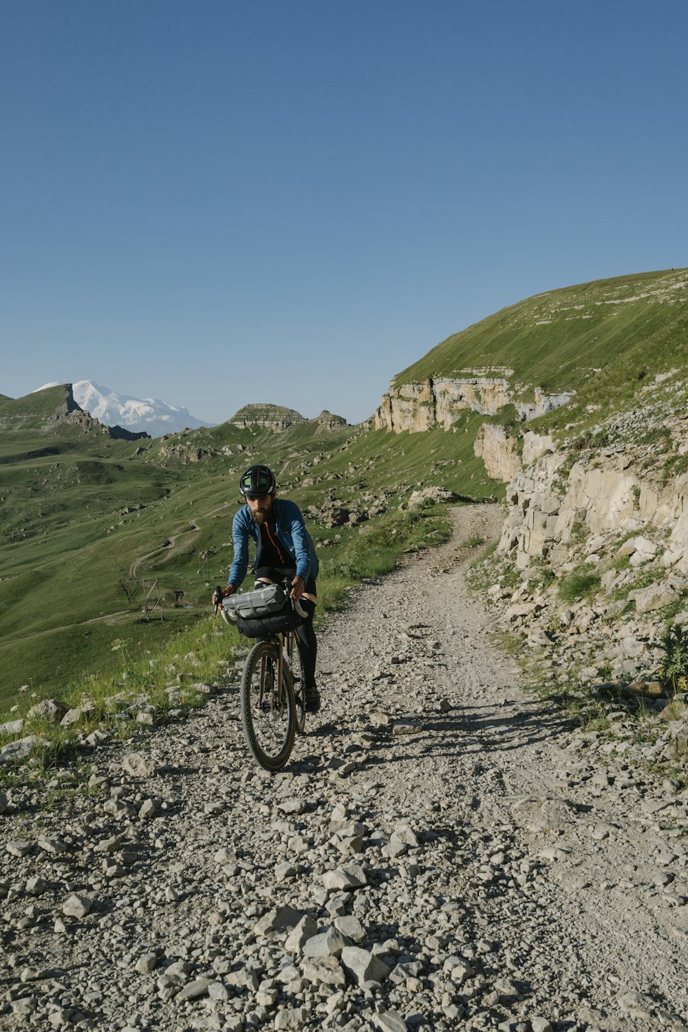 a man riding a bike down a dirt road