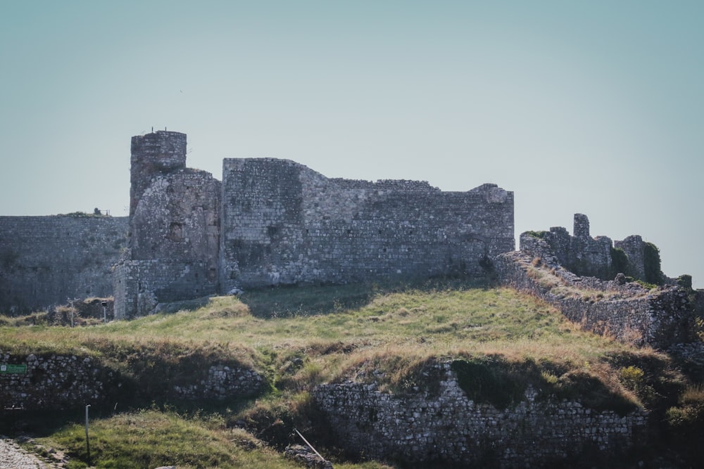 a stone castle sitting on top of a lush green hillside