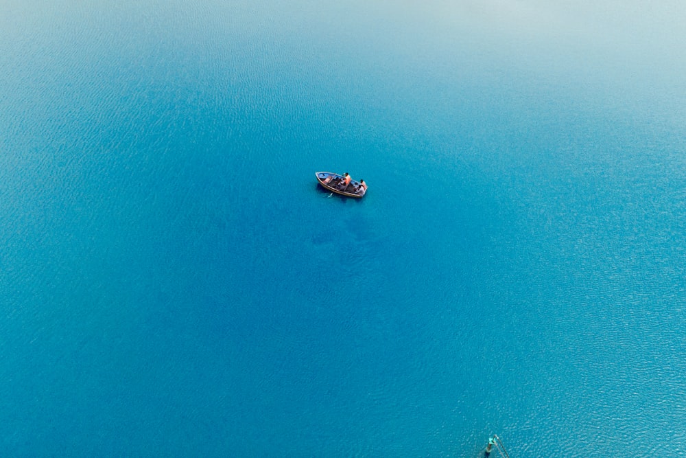 a small boat floating on top of a large body of water