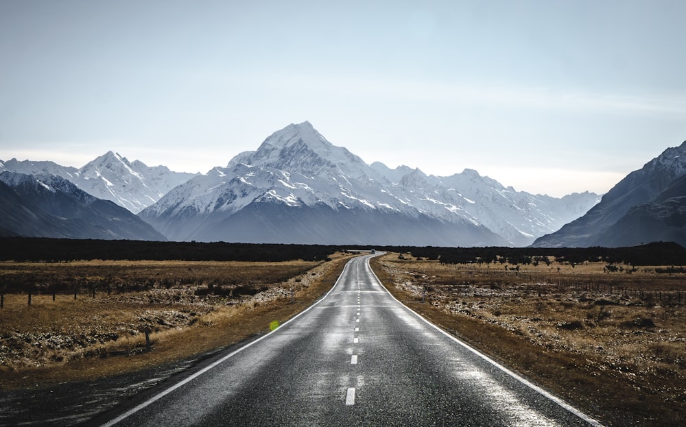 an empty road with mountains in the background