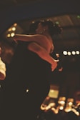 a woman in a black dress is holding a man in a black suit