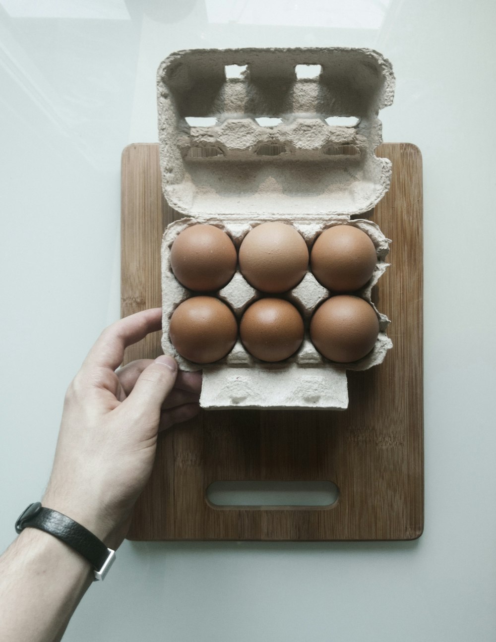 a person is holding a carton of eggs