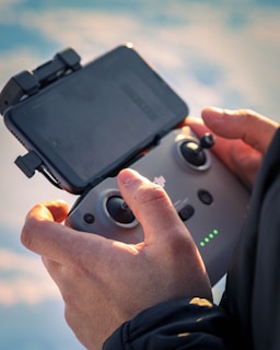 Close-up of a drone controller in hands during a sunny day on the farm.
