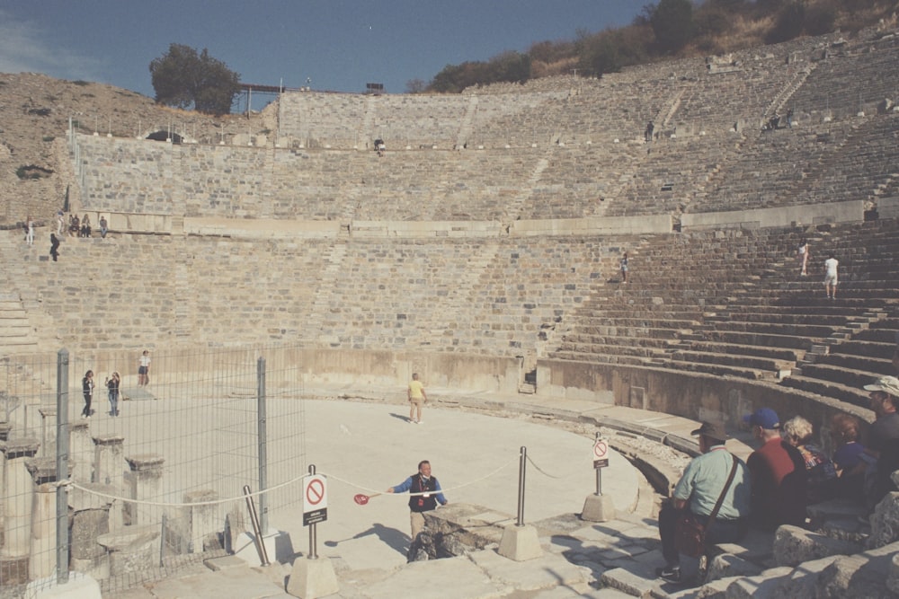 a group of people standing around a stone arena