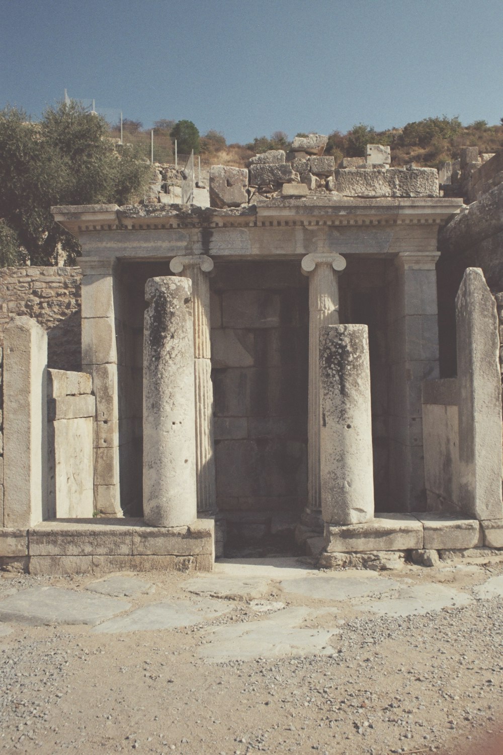 un edificio de piedra con columnas y un reloj encima