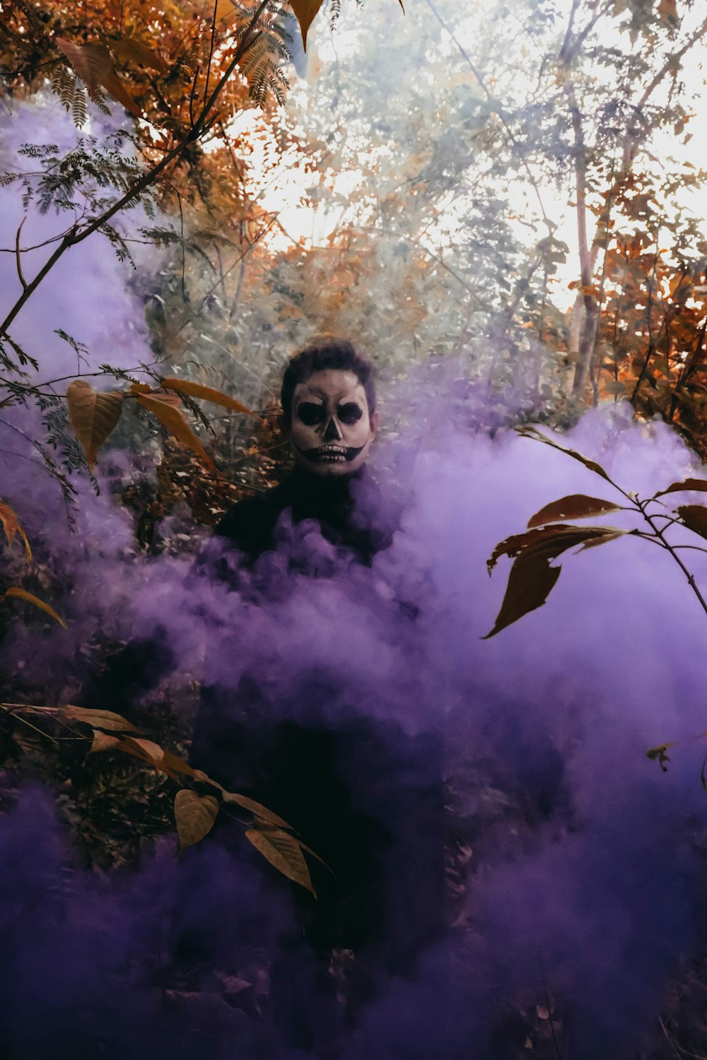 a man with a creepy face is surrounded by smoke