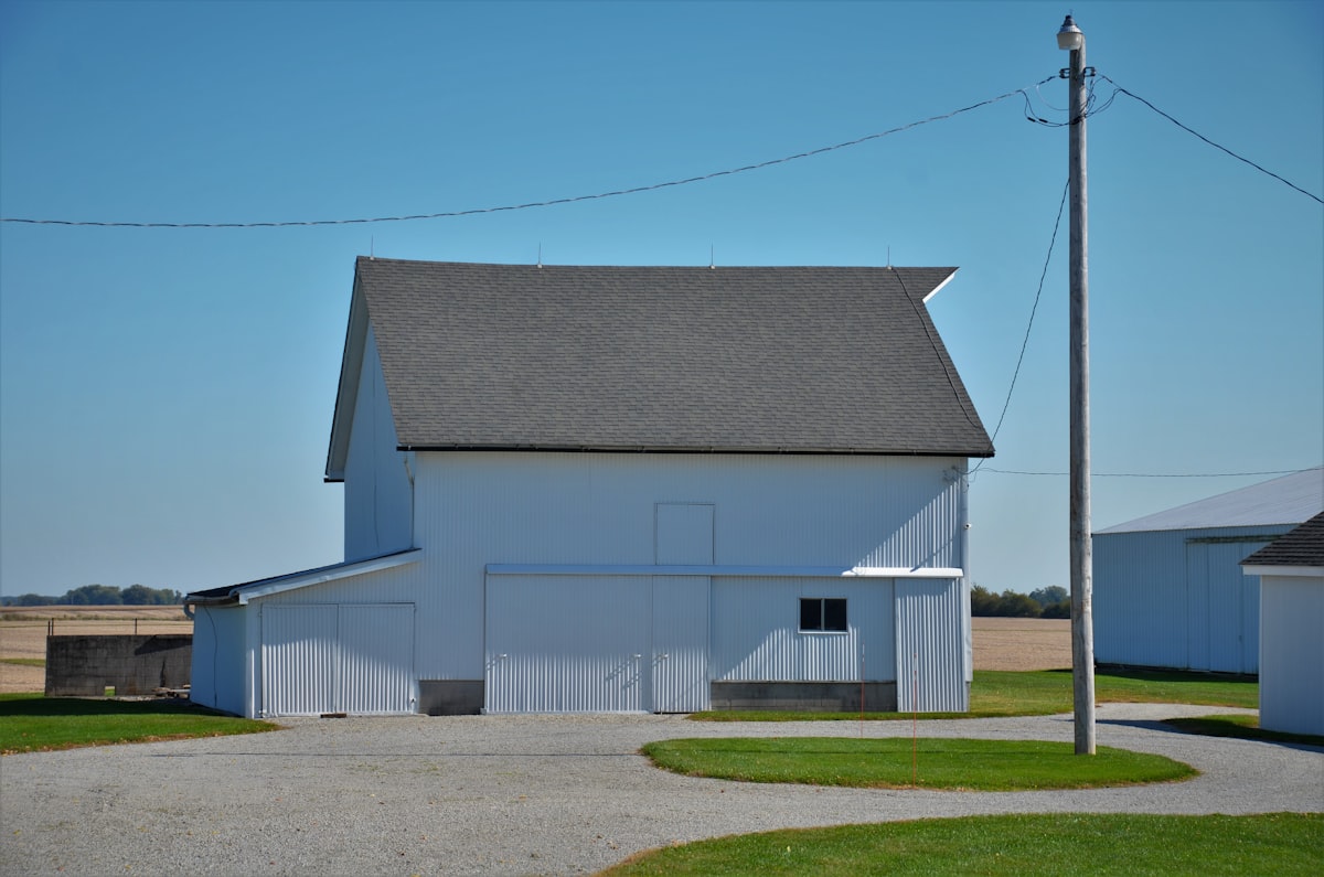 A large white barn with a black roof